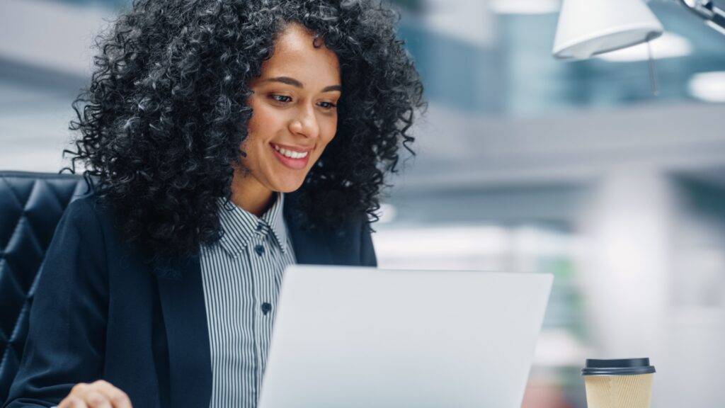 Happy professional working on a laptop in an office