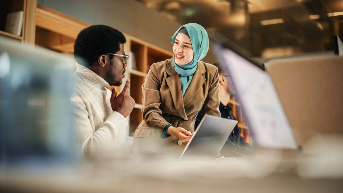 Male and female corporate professionals talking in an office
